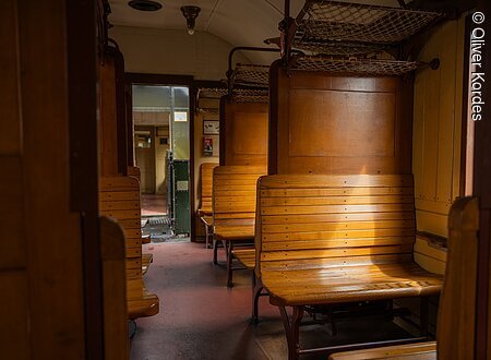 Dampfbahn (Ebermannstadt, Fränkische Schweiz) Innenraum eines historischen Zugwaggons mit Holzbänken und Gepäcknetzen.