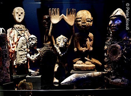 Afrikana Museum (Bad Steben, Frankenwald) Verschiedene traditionelle Holzskulpturen und Figuren in einem Ausstellungsraum.